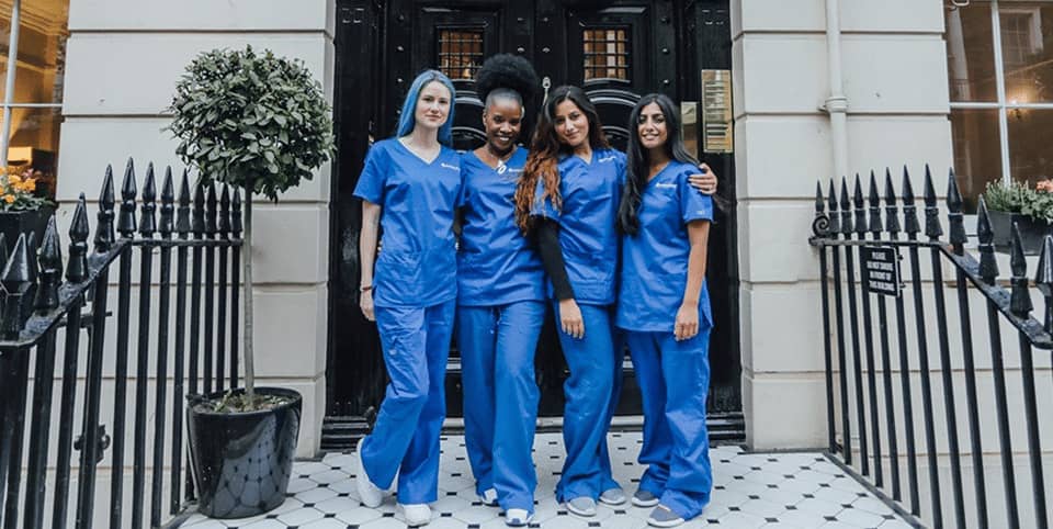 Four nurses in blue scrubs outside a Georgian clinic entrance, Sofwave ultrasound skin lifting Dublin